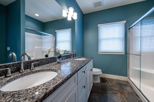 bathroom with a healthy amount of sunlight, an enclosed shower, and vanity