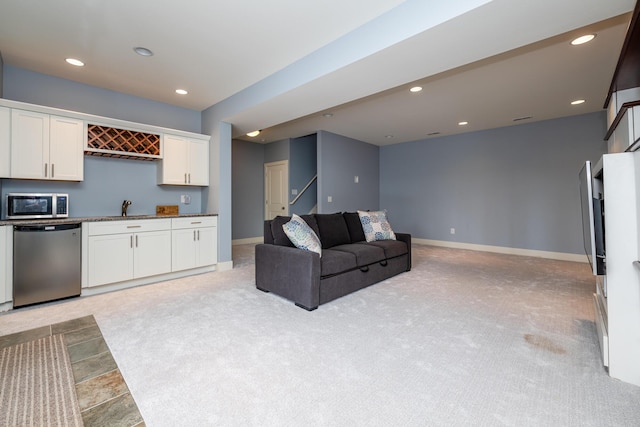 kitchen featuring white cabinetry, sink, light carpet, and appliances with stainless steel finishes