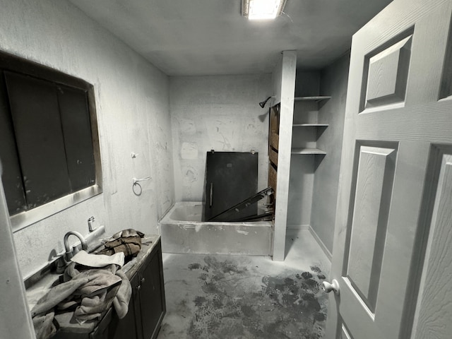 bathroom with concrete flooring and a bathtub