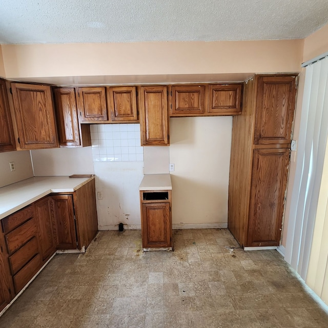 kitchen with a textured ceiling and decorative backsplash