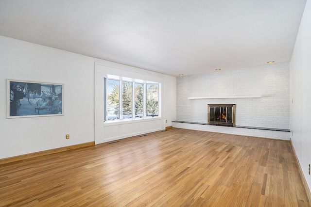 unfurnished living room featuring a fireplace and light hardwood / wood-style flooring