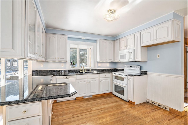 kitchen with sink, white cabinetry, kitchen peninsula, white appliances, and light hardwood / wood-style floors