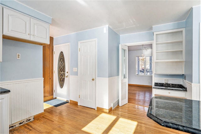 kitchen with an inviting chandelier, light hardwood / wood-style flooring, and white cabinets