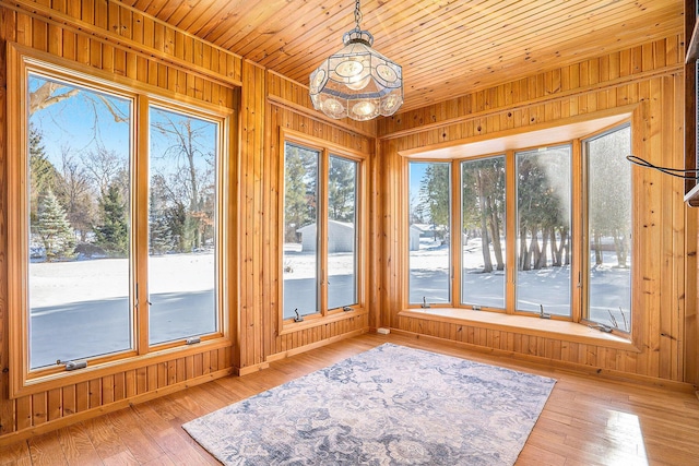 unfurnished sunroom featuring wood ceiling and a wealth of natural light