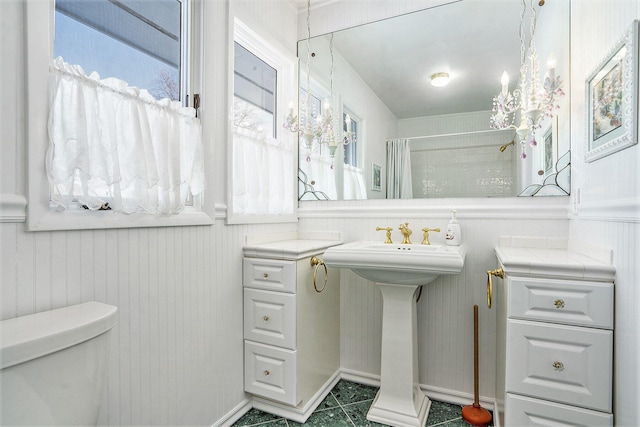 bathroom with sink, curtained shower, and toilet