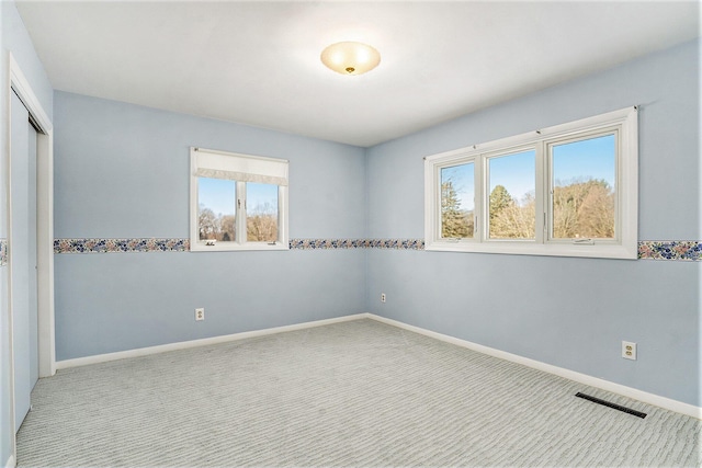 carpeted empty room featuring a wealth of natural light