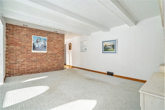 interior space with brick wall, carpet flooring, and beam ceiling