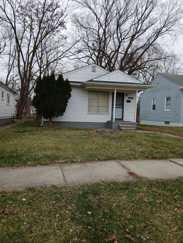 bungalow-style house featuring covered porch and a front lawn