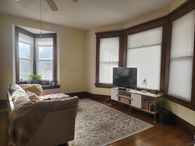 living room featuring dark wood-type flooring and ceiling fan