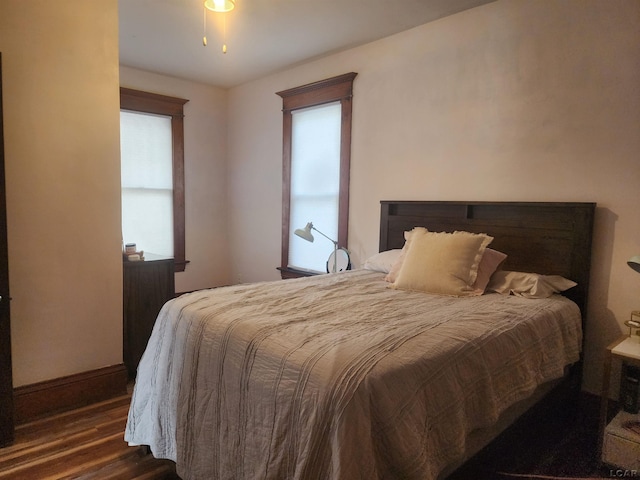 bedroom featuring multiple windows and dark hardwood / wood-style floors