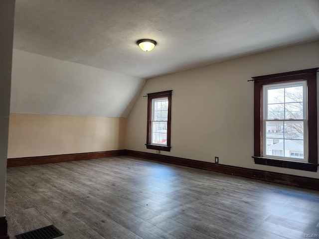 additional living space with lofted ceiling and dark hardwood / wood-style floors