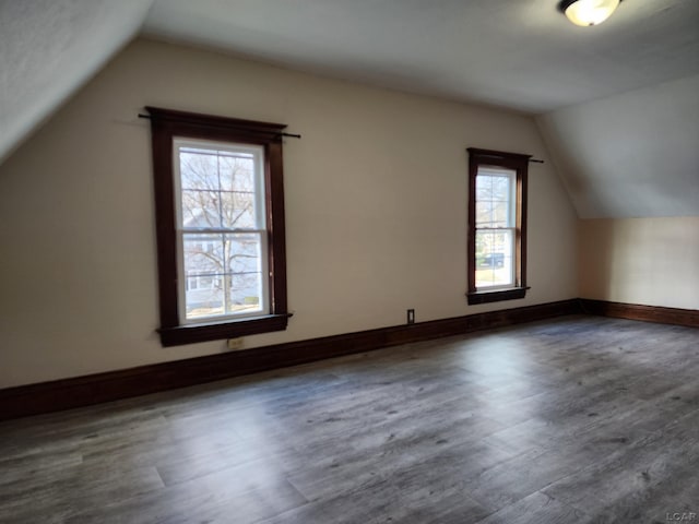 bonus room with vaulted ceiling and dark hardwood / wood-style floors