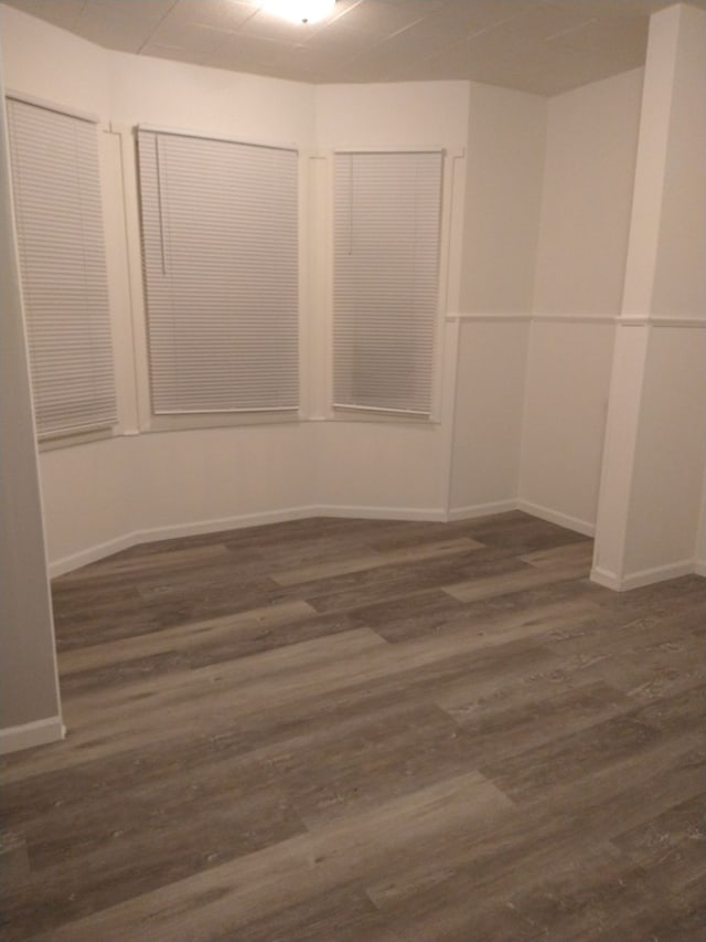 unfurnished room with dark hardwood / wood-style flooring