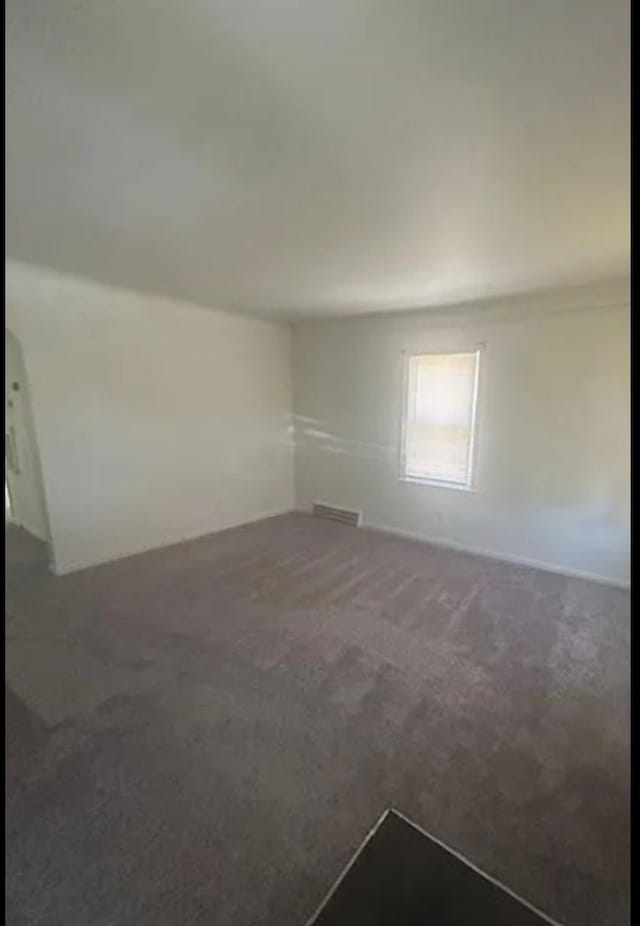 unfurnished room featuring dark carpet