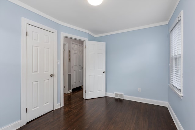 unfurnished bedroom with ornamental molding and dark hardwood / wood-style flooring