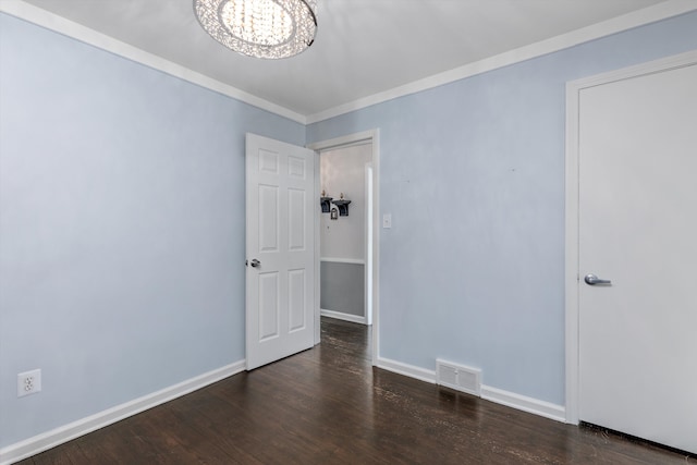 spare room featuring ornamental molding, dark hardwood / wood-style floors, and a notable chandelier