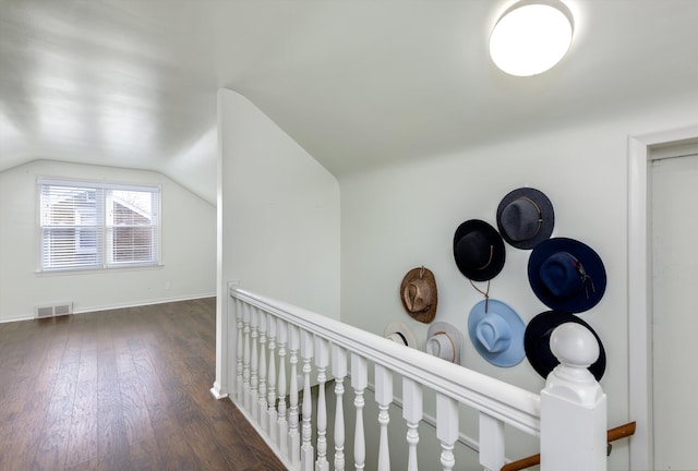 hallway featuring dark hardwood / wood-style flooring and vaulted ceiling