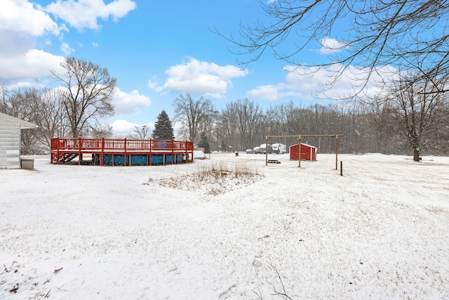 yard layered in snow with a wooden deck