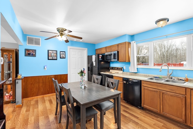 kitchen with sink, light hardwood / wood-style flooring, ceiling fan, and black appliances