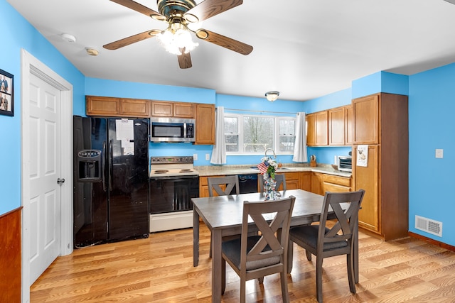 kitchen featuring sink, light wood-type flooring, white electric range oven, and black fridge with ice dispenser