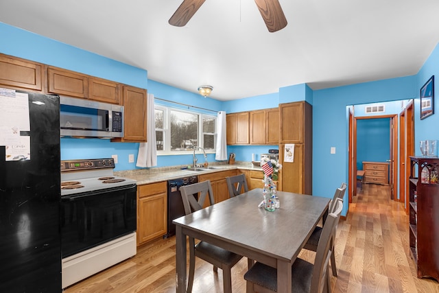 kitchen featuring sink, black appliances, light hardwood / wood-style floors, and ceiling fan