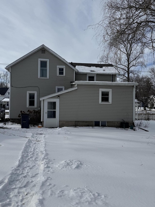 view of snow covered rear of property