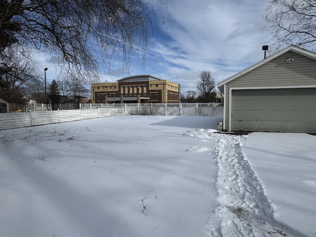 yard covered in snow with an outbuilding and a garage