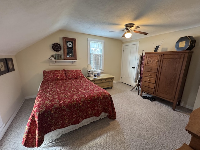 carpeted bedroom with ceiling fan, vaulted ceiling, and a textured ceiling