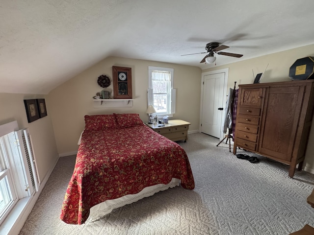 bedroom featuring vaulted ceiling, light carpet, ceiling fan, and a textured ceiling