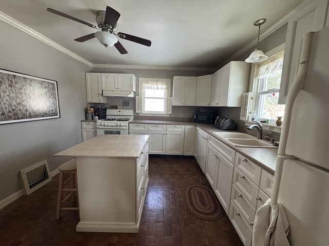 kitchen featuring sink, white appliances, ornamental molding, white cabinets, and decorative light fixtures