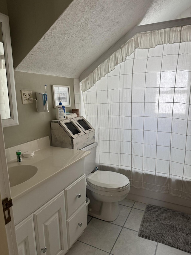 bathroom featuring vanity, a textured ceiling, vaulted ceiling, tile patterned floors, and toilet