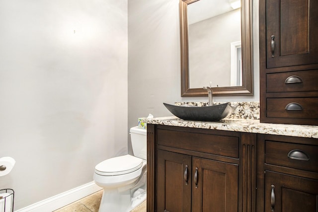 bathroom with tile patterned flooring, vanity, and toilet