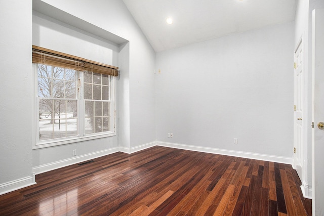 spare room with vaulted ceiling, plenty of natural light, and dark hardwood / wood-style flooring