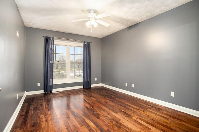 spare room featuring dark wood-type flooring and ceiling fan