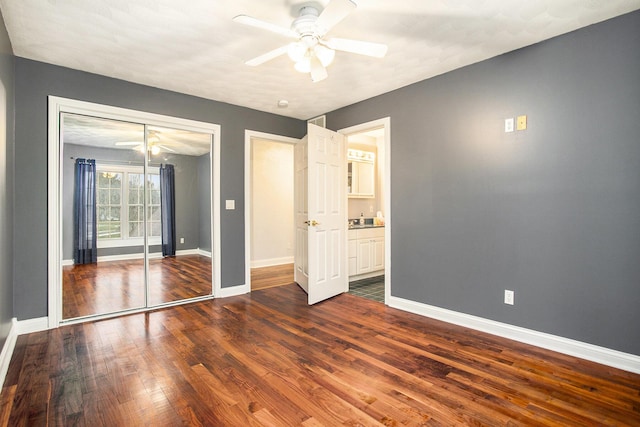 unfurnished bedroom featuring dark hardwood / wood-style flooring, sink, a closet, and ceiling fan