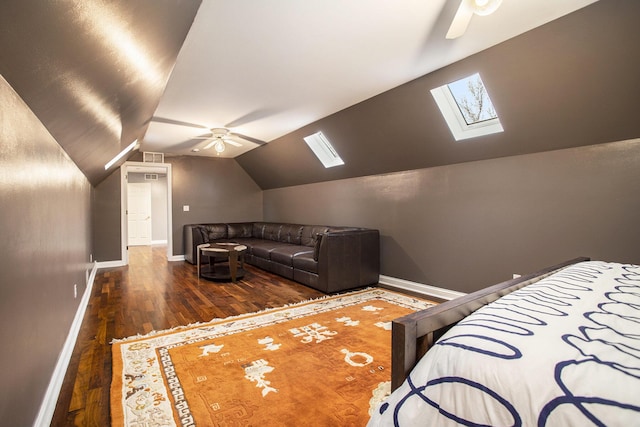 bedroom with ceiling fan, dark hardwood / wood-style floors, and vaulted ceiling with skylight