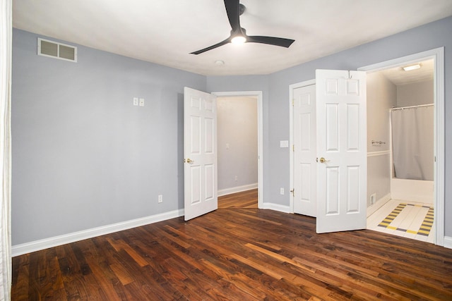 unfurnished bedroom featuring dark wood-type flooring, ceiling fan, and ensuite bathroom