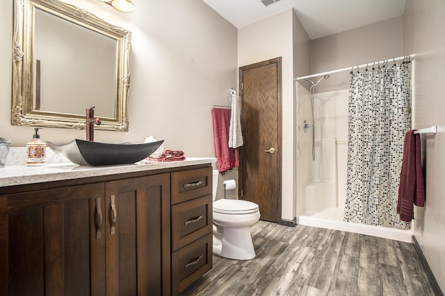 bathroom featuring vanity, hardwood / wood-style floors, a shower with curtain, and toilet