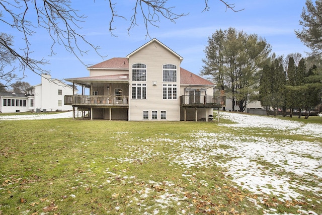 rear view of house with a wooden deck and a yard