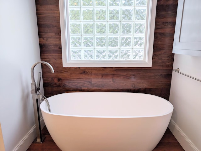 bathroom with wooden walls and a washtub