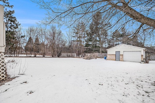 yard covered in snow with a garage and an outdoor structure