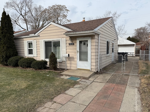 view of front of home with a garage, an outdoor structure, and a front yard