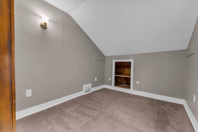 bonus room featuring vaulted ceiling and carpet