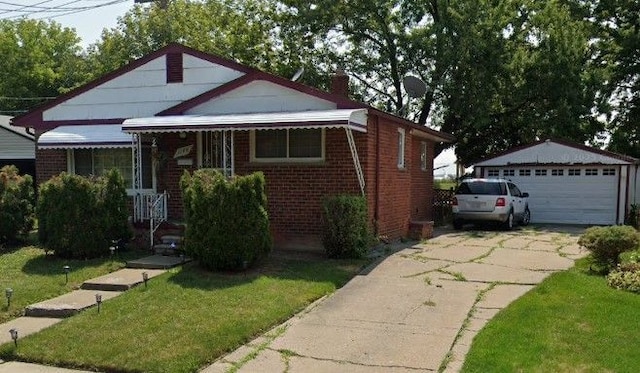 bungalow with a garage, an outdoor structure, and a front lawn