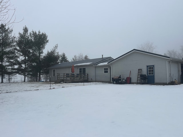 snow covered house with a wooden deck