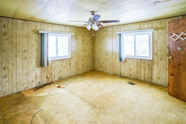 unfurnished room with carpet, a healthy amount of sunlight, and ceiling fan