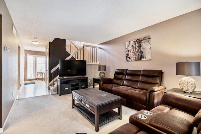 carpeted living room featuring a textured ceiling