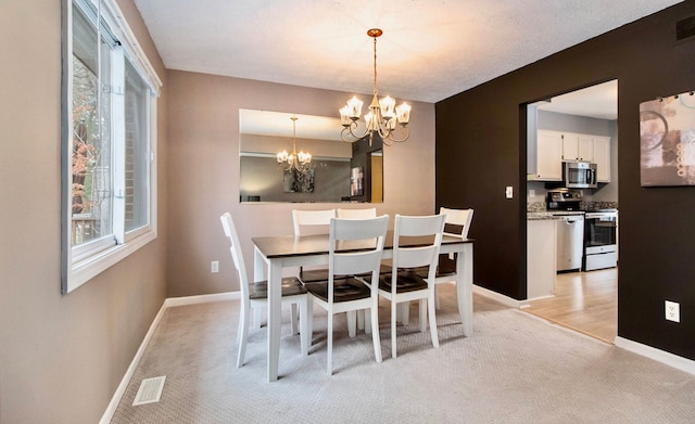 dining room featuring an inviting chandelier and light carpet