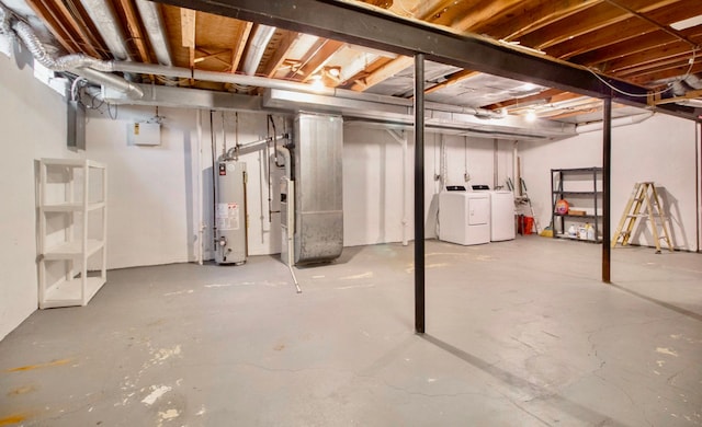 basement featuring heating unit, independent washer and dryer, and water heater