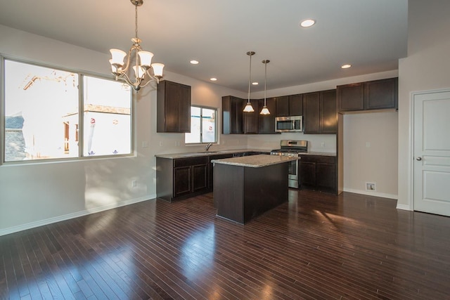 kitchen featuring a kitchen island, appliances with stainless steel finishes, dark wood-type flooring, dark brown cabinets, and a sink